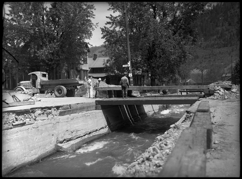 People examining a bridge after a flood in Wallace, Idaho.