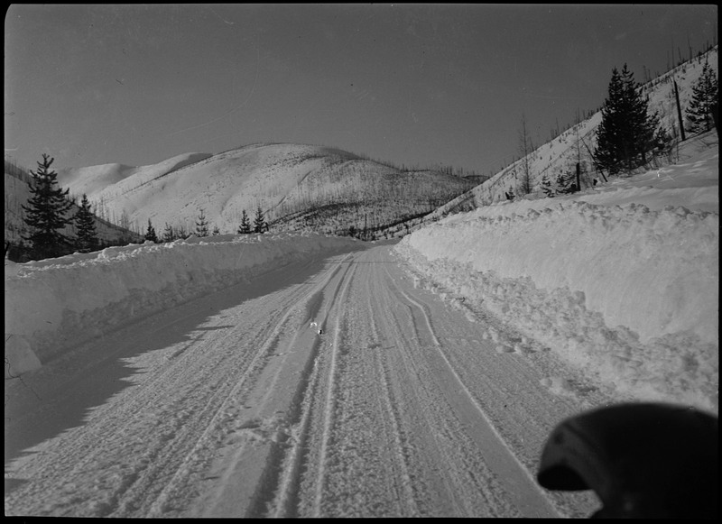 Image of the plowed road at Lookout Pass. There appears to be several feet of snow on the side of the road.