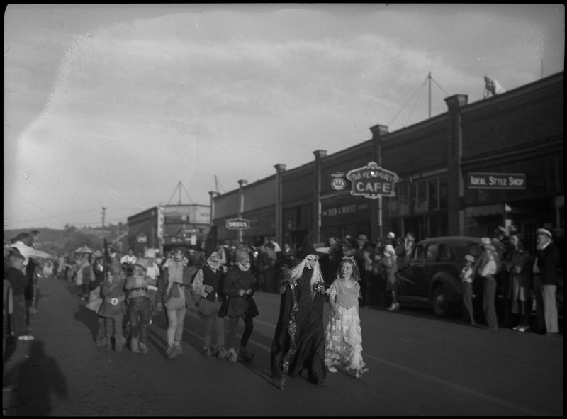 Children wearing costumes during the Kellogg Kiddie parade. Spectators watch from the sidewalk.