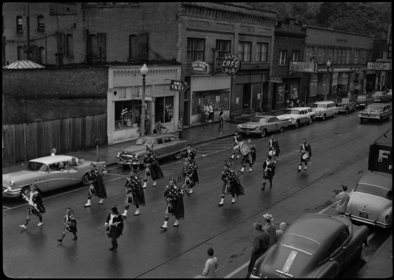 Pipers wearing matching kilts perform in the Benevolent and Protective Order of the Elks parade. Spectators watch from the sidewalk.