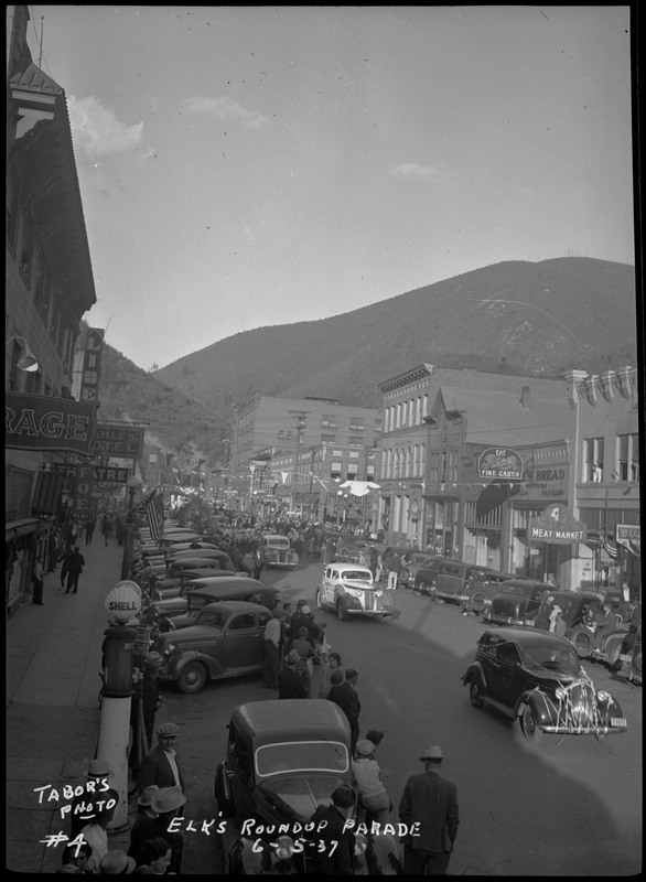 Street view of a line of floats and decorated cars during the Benevolent and Protective Order of Elks parade.