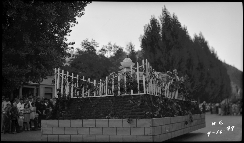 A float decorated to look like a garden with vines, a fence, and what looks like a fountain during the Benevolent and Protective Order of Elks roundup parade.
