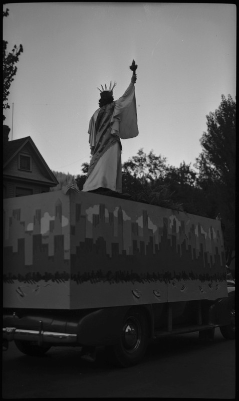 Back view of a woman dressed up as the Statue of Liberty standing on a float during the Benevolent and Protective Order of Elks day parade.