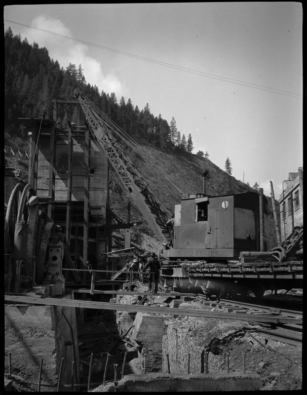 Workers working near large machinery, possibly in a mine in Burke, Idaho. 