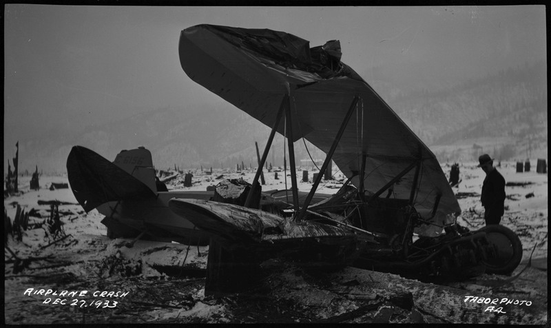 A man looks at the remnants from an airliner crash. Caption on the bottom left reads "Airplane Crash Dec. 27 1933."
