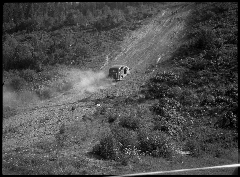 A car going up a hill during a motorcycle hill climb.