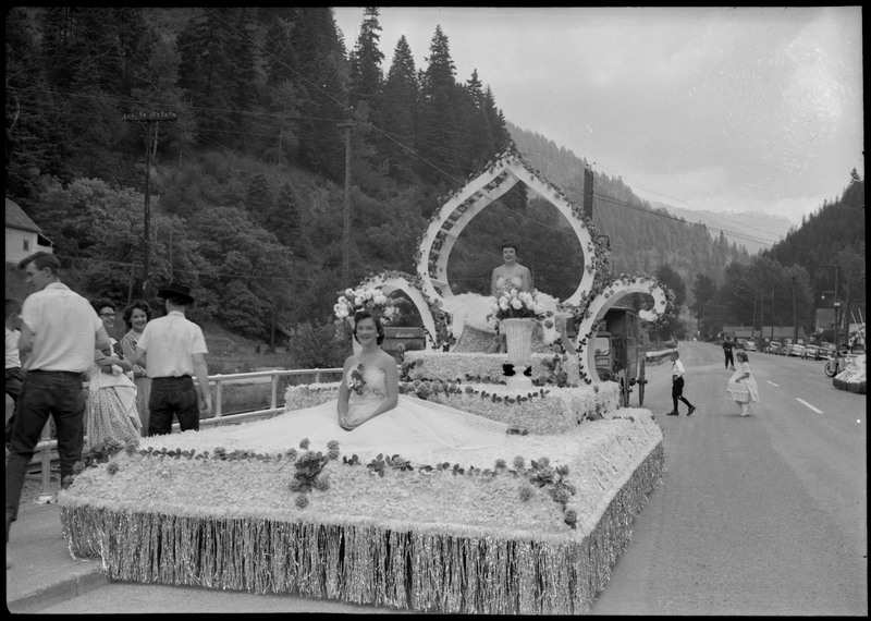 Two women dressed in gowns sit on an elaborately decorated float during the Silver Jubilee.