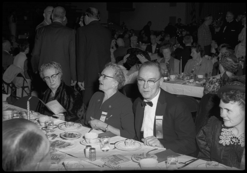 People dressed in formal wear seated at a table during the Silver Jubilee banquet.