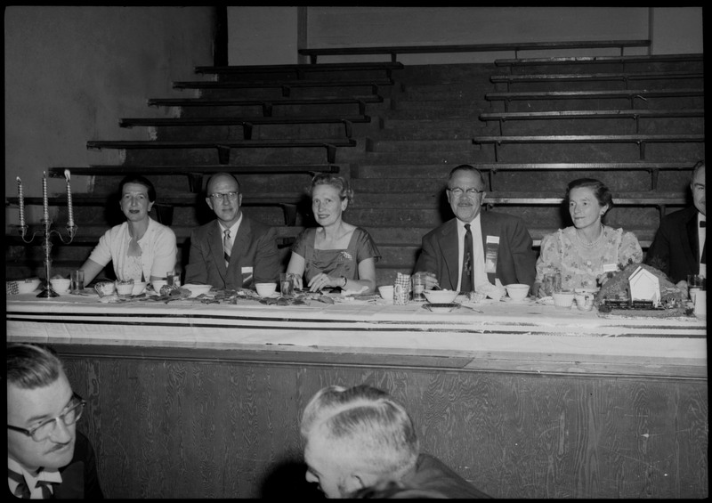 People dressed in formal wear seated at a table during the Silver Jubilee banquet.
