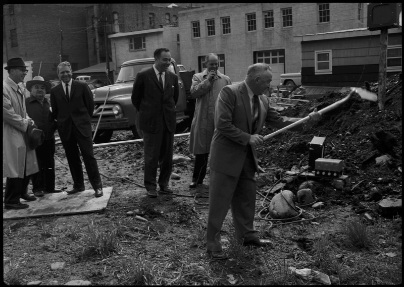 A man holds a shovel as five other men watch on during the Stardust Motel dedication.
