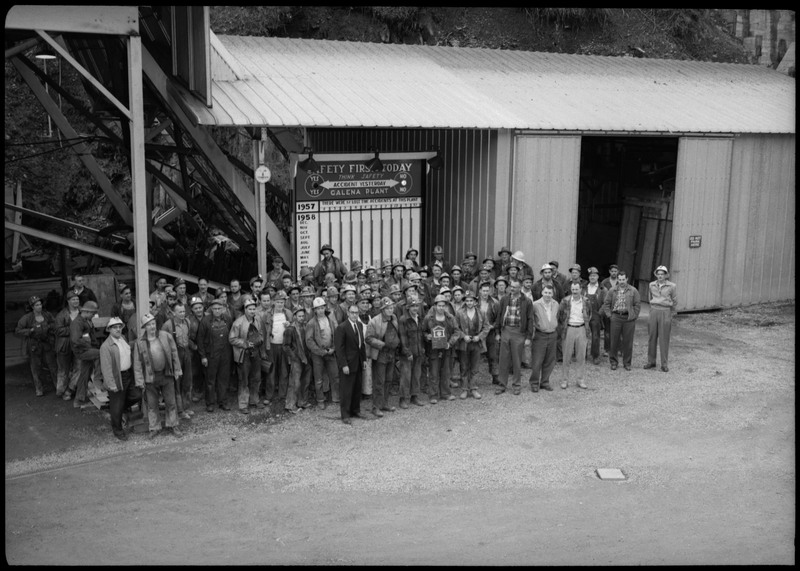 Group photograph of the workers at the Galena plant receiving the Galena Safety Award. They are standing in front of a safety board.
