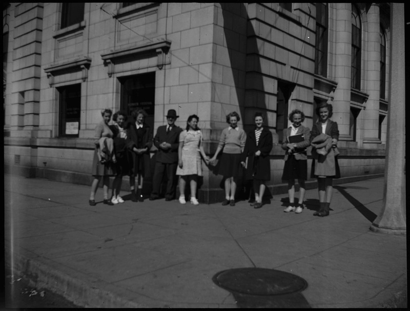 People standing on a curb during the Boys and Girls Week.