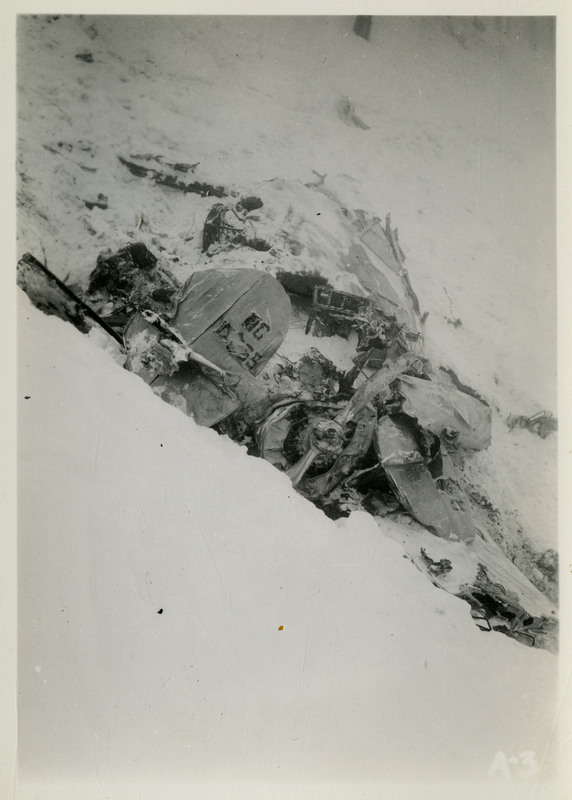 Debris from an airliner crash partially covered in snow, including a turbine part.