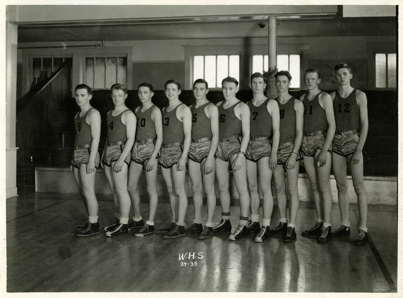 The 1934-1935 Wallace High School basketball team pose, wearing their uniforms. "W.H.S. 34 35" is written in the bottom center of the photograph.
