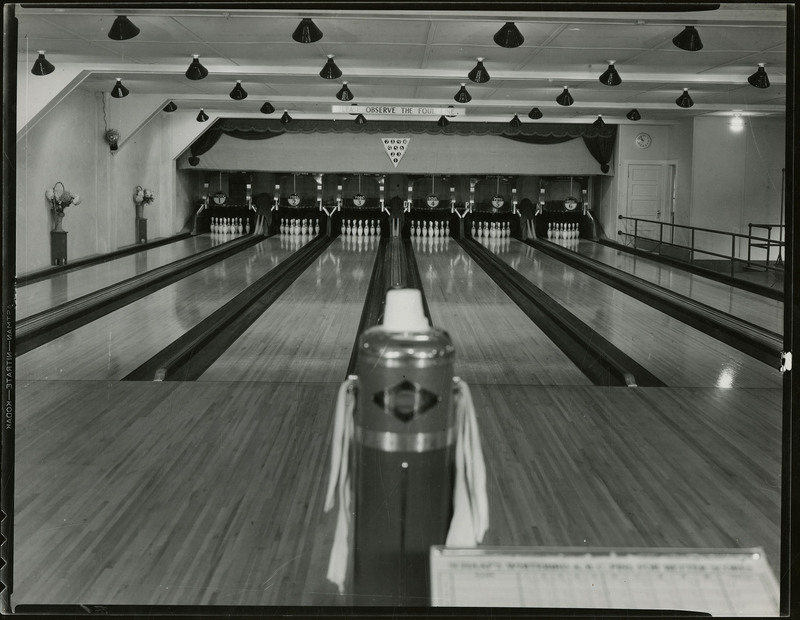 The interior of the Wallace bowling alley. A sign above the bowling lane reads "Please observe the foul line."