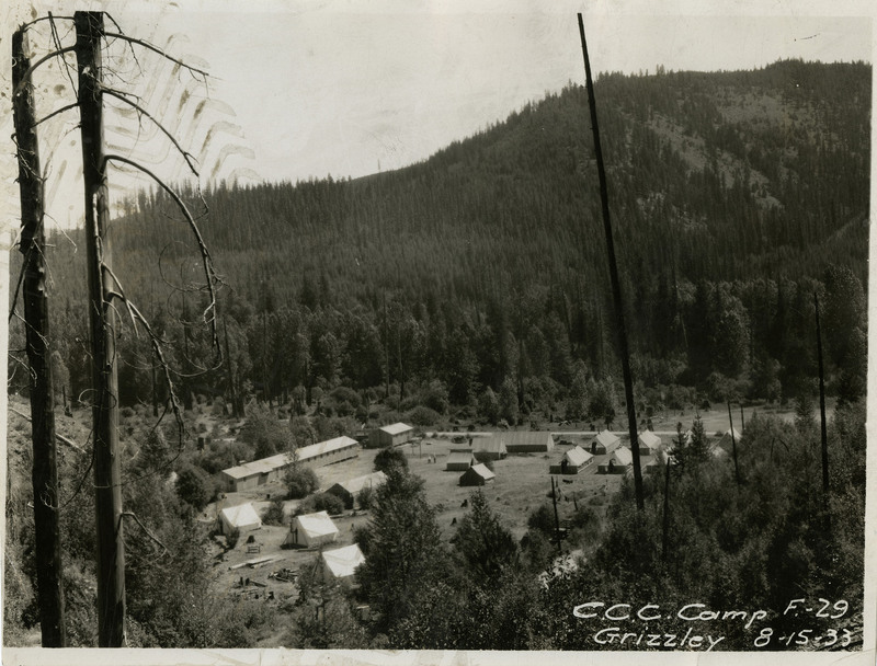 A view of the Civilian Conservation Corps Grizzley Camp in Wallace. Trees and mountains surround the camp.