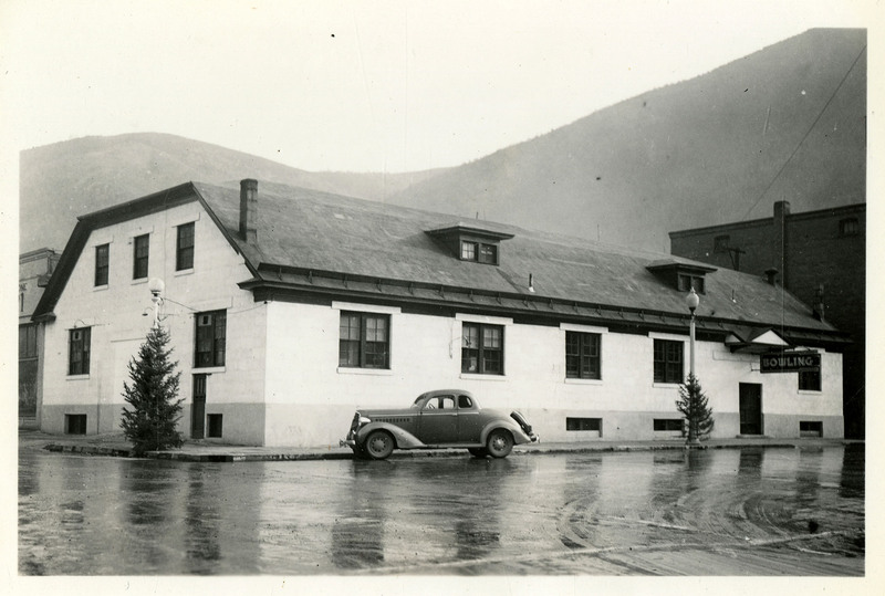 A view of the Wallace Bowling Alley building. An automobile can be seen parked in front of it.