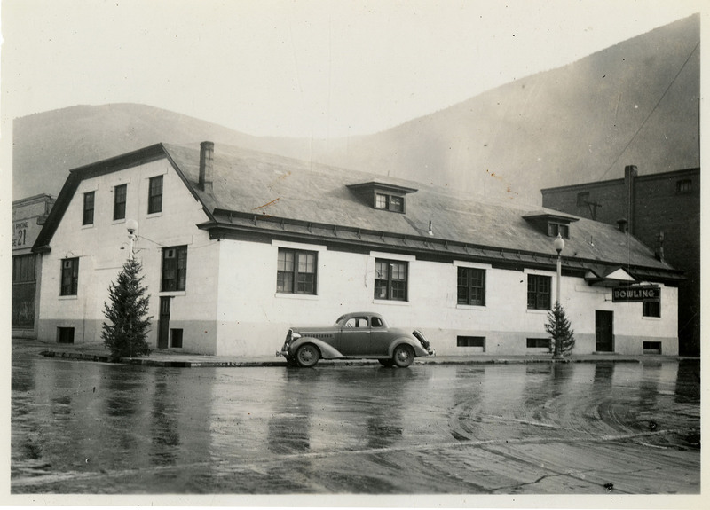 A view of the Wallace Bowling Alley. An automobile can be seen parked in front of it.