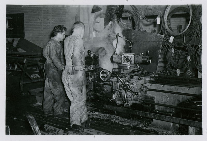 Two men looking at mining machinery.