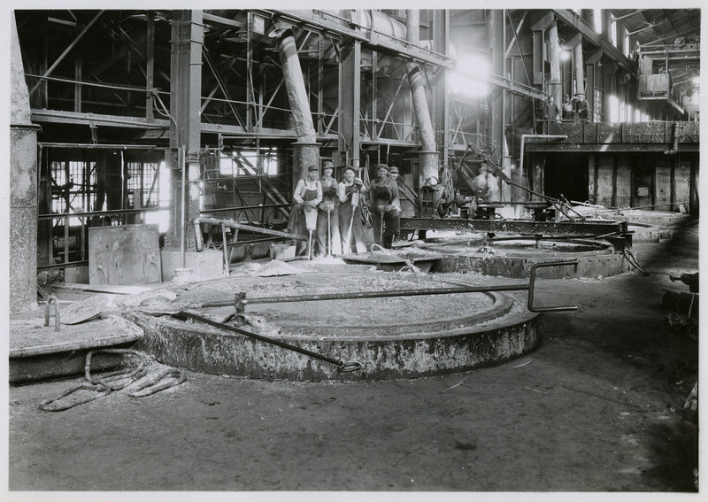 Several miners standing next to drossing pots in the Bunker Hill Smelter.