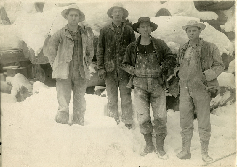 Four miners standing in the snow.