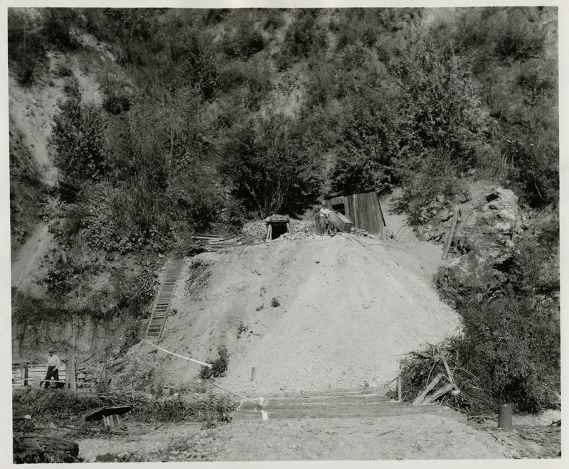 View of outside a mine. Two workers can be seen.
