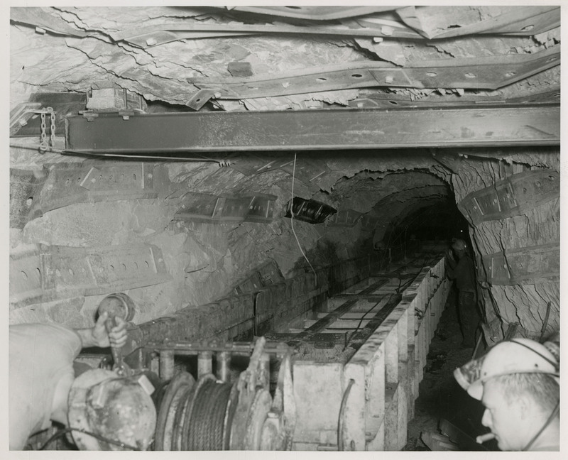 Three miners working in a mine and operating mining machinery
