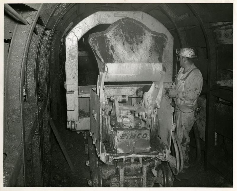 A miner works with mining machinery.