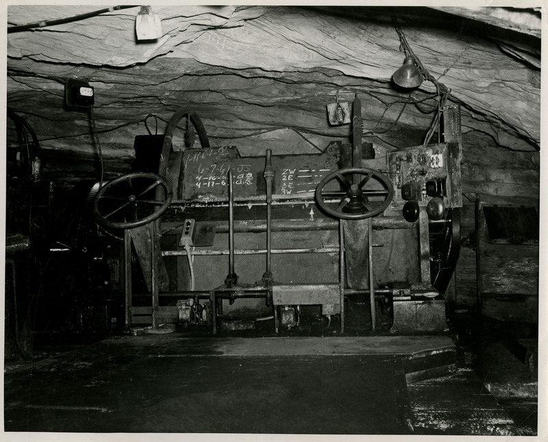 View of mining machinery with wheels inside a tunnel.