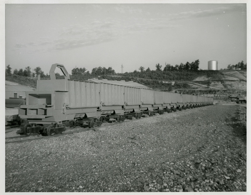 View of mining carts on tracks outside.