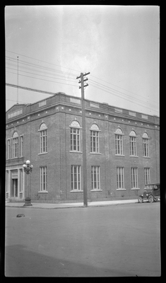 Photo of part of the Benevolent and Protective Order of Elks building in what is likely Wallace, Idaho. There is a car parked on the side of the road next to the building.