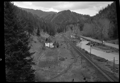 Photo of what appears to be a house in the distance. Described as "Standard Dairy, E. F. Gentry." The photo was taken from a higher elevation and looks down at the building from the side. There is a river that runs near by the building.