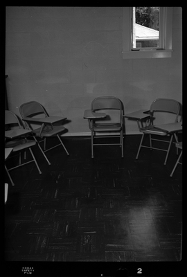 Photo of a group of metal chairs with desk space arranged in a semi circle in a small room. They are within an Episcopal Church in Wallace, Idaho.