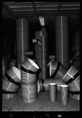 Photo of Spunstrand Incorporated equipment in a room, possibly HVAC system work. There are several tubes with curves in them coming out of the floor, none of which are connected.