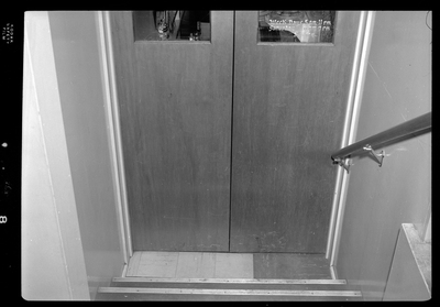 Photo of the stairs that lead down to the doors of the Hotel Pacific Cafe. On the window of the door is a decal reading "Week days 5am-11pm; Saturday 6am-9pm; Sunday."