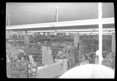 Photo of the interior of the Food Center Thrift Store overlooking most of the store. The shelves are stocked with food and non food products.