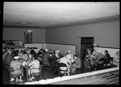 Several tables of women sitting together while eating and celebrating Mother's Day with the Benevolent and Protective Order of Elks. The women are all well dressed.
