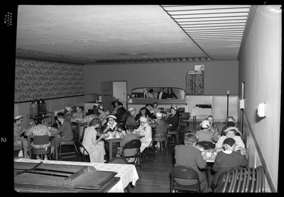 Several tables of women sitting together while eating and celebrating Mother's Day with the Benevolent and Protective Order of Elks. The women are all well dressed.