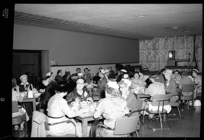 Several tables of women sitting together while eating and celebrating Mother's Day with the Benevolent and Protective Order of Elks. The women are all well dressed.