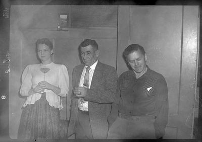 Two men and a woman at a Rotary Club party. They are all well dressed.