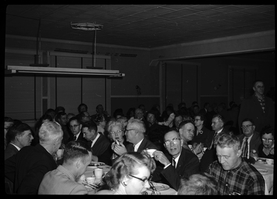 Photo of several groups of people seated at tables, eating together, for the 60th anniversary celebration of Fraternal Order of Eagles.