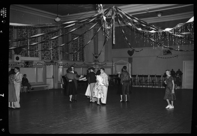 Photo of a handful of couples dancing together at the Fraternal Order of Eagles Valentine's Day dance. The room is highly decorated.