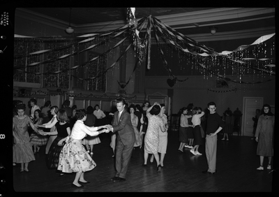 A large group of people dancing together, mostly in pairs, for the Fraternal Order of Eagles Valentine's Day dance. The room is highly decorated.
