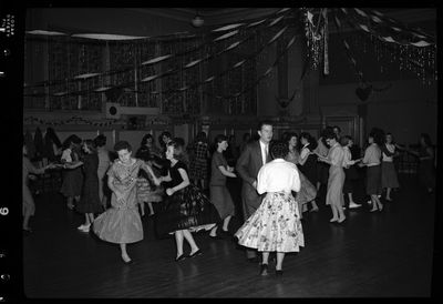 A large group of people dancing together, mostly in pairs, for the Fraternal Order of Eagles Valentine's Day dance. The room is highly decorated.