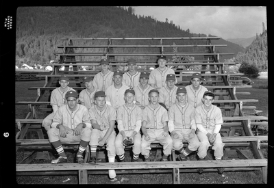 The Legion baseball team members are sitting together on bleachers for a group photo. They are wearing matching baseball uniforms.