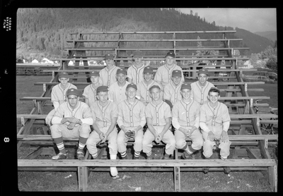 The Legion baseball team members are sitting together on bleachers for a group photo. They are wearing matching baseball uniforms.