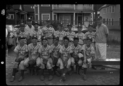 Group photo of the little league all-star baseball team and their coaches. Most of the children are wearing matching baseball uniforms with "Goodman's Royal Tire" on the front.