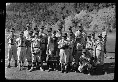 Group photo of the little league all-star baseball teams and their coaches. Most of the children are wearing matching baseball uniforms with various names on them: Rotary, Gyro, Hecla, Gene's.