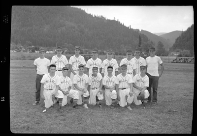 Photo of the Babe Ruth all-star baseball team and their coaches at the little league baseball tournament. They are lined up in rows for the photo, the front row taking a knee. The team are all wearing matching uniforms.
