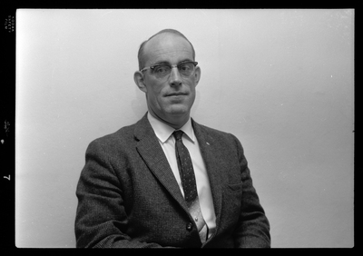 Photo of a man wearing a suit and glasses. Possibly Bill Featherstone.